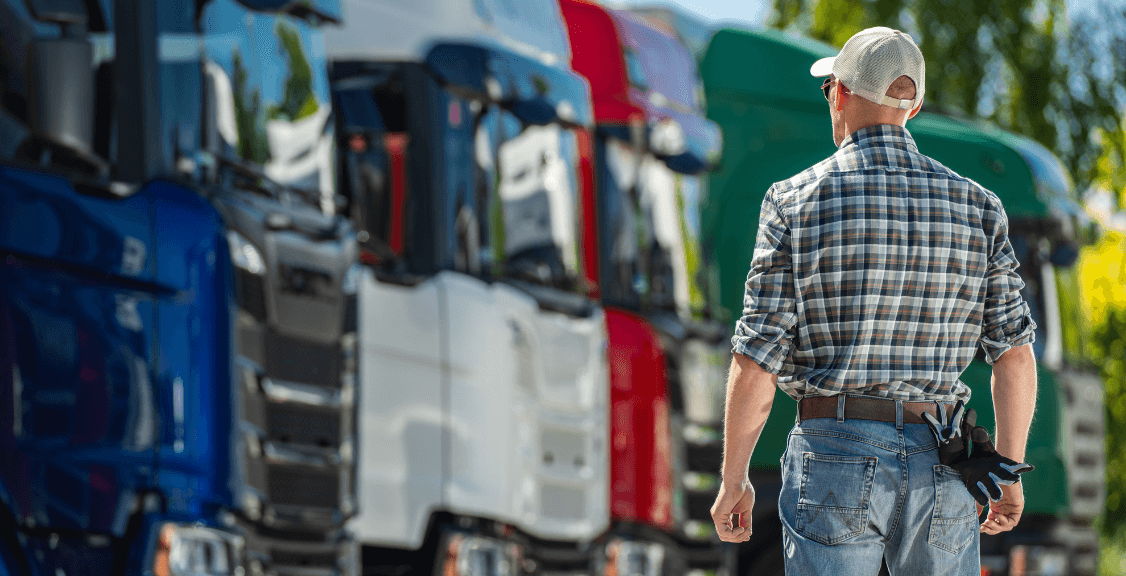 owner Inspecting Fleet of Colorful Trucks at Transportation Yard