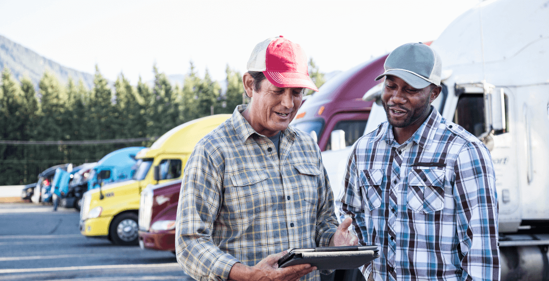  truck driving team together in a truck stop parking lot