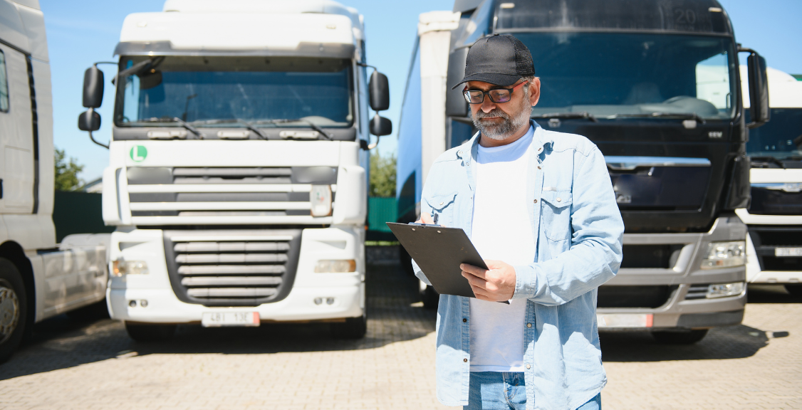 Happy confident male driver standing in front on his truck