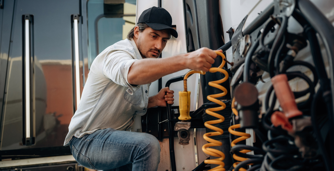 Truck driver messing with cables, installation, and fixing hardwares.
