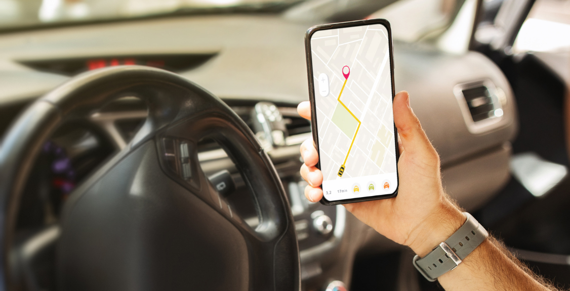 Man driver holding mobile phone with map gps navigation