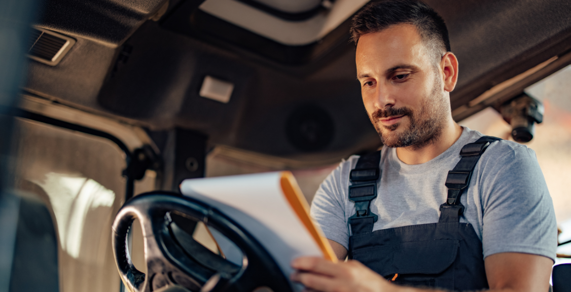 Truck driver checking papers for eld maintenance