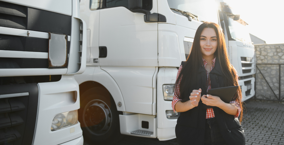 Portrait of a beautiful woman truck driver standing in the parking lot