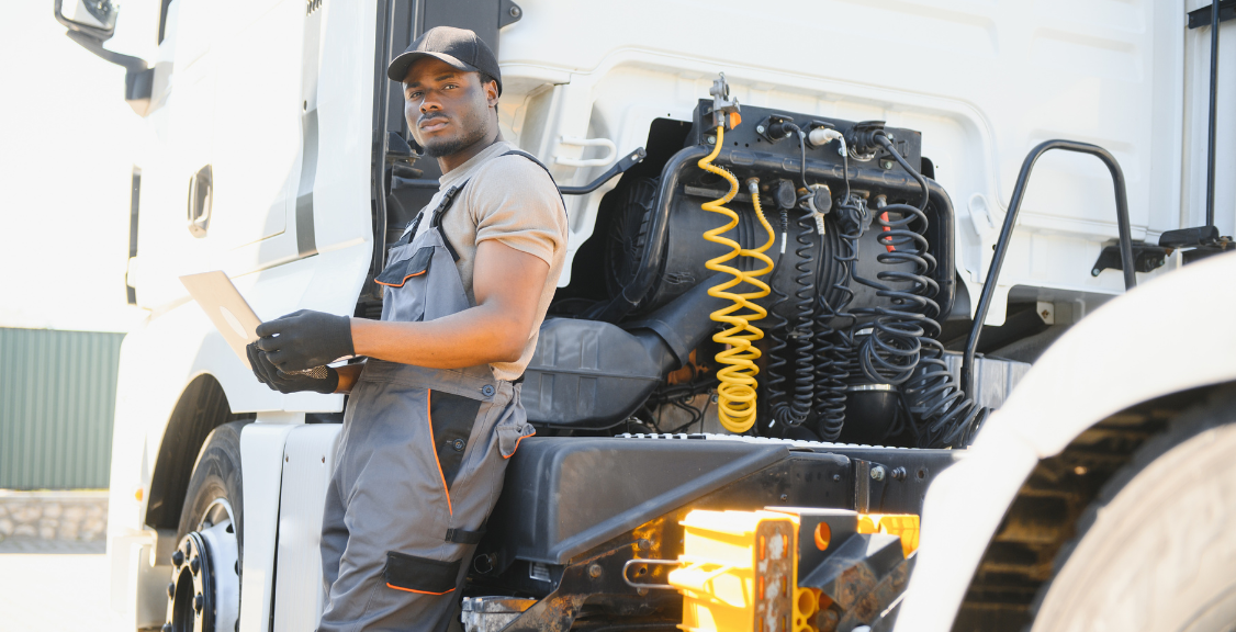 Truck repair service. African american Mechanic makes computer diagnostic of the semitruck