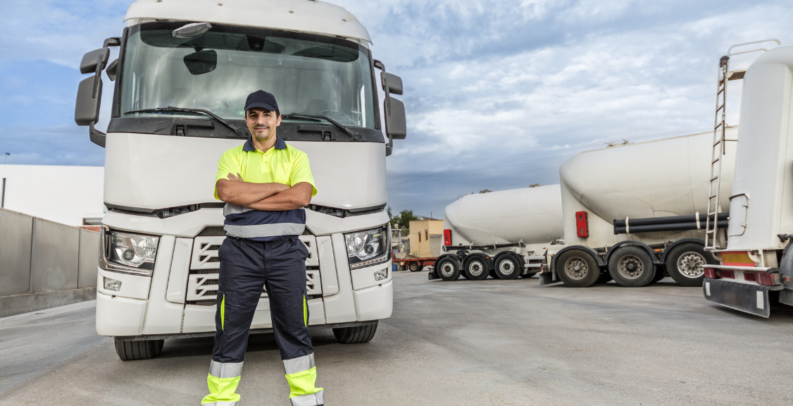 a driver in front of a large white truck