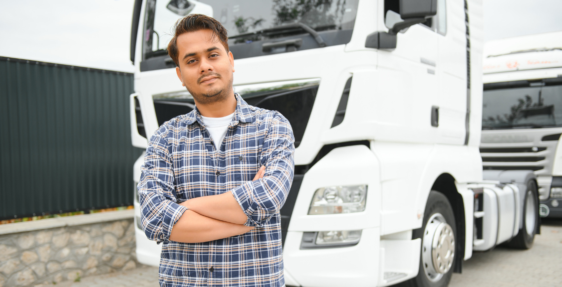 a driver in front of a white big truck