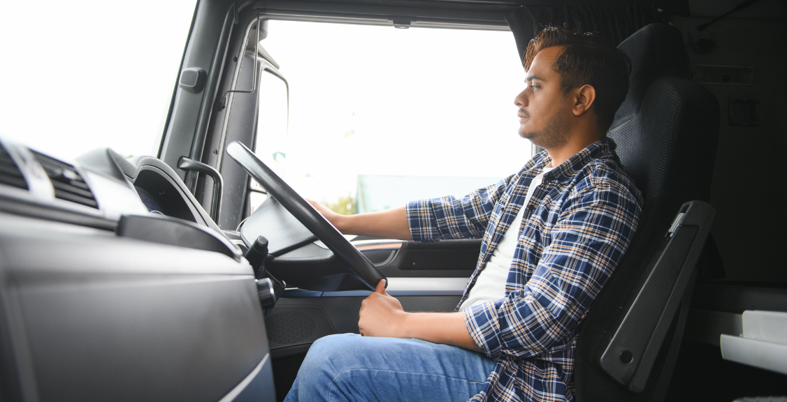 a driver on a truck checking side mirrors