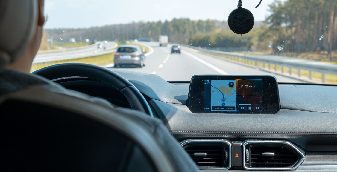 a man driving on a car with gps display