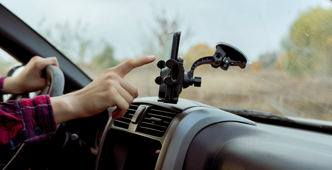 car driver hand point finger using smartphone application with map navigator to find the way