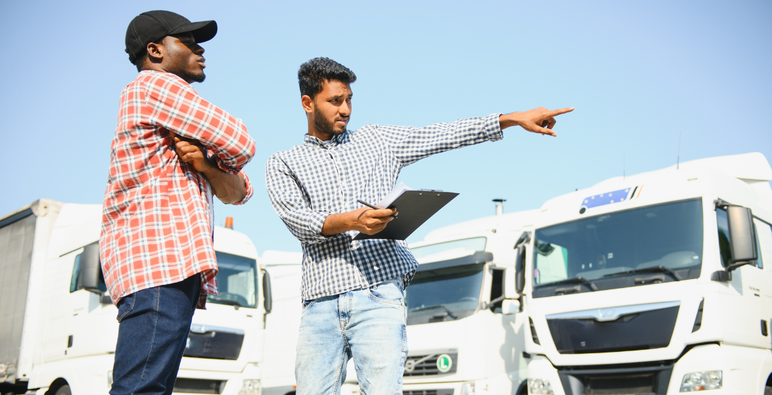 driver and fleet manager pointing on trucks