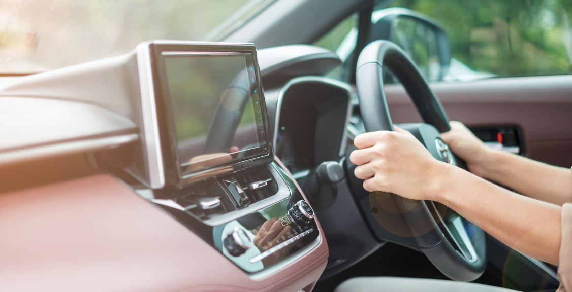 driver driving a car on the road, hand controlling steering wheel